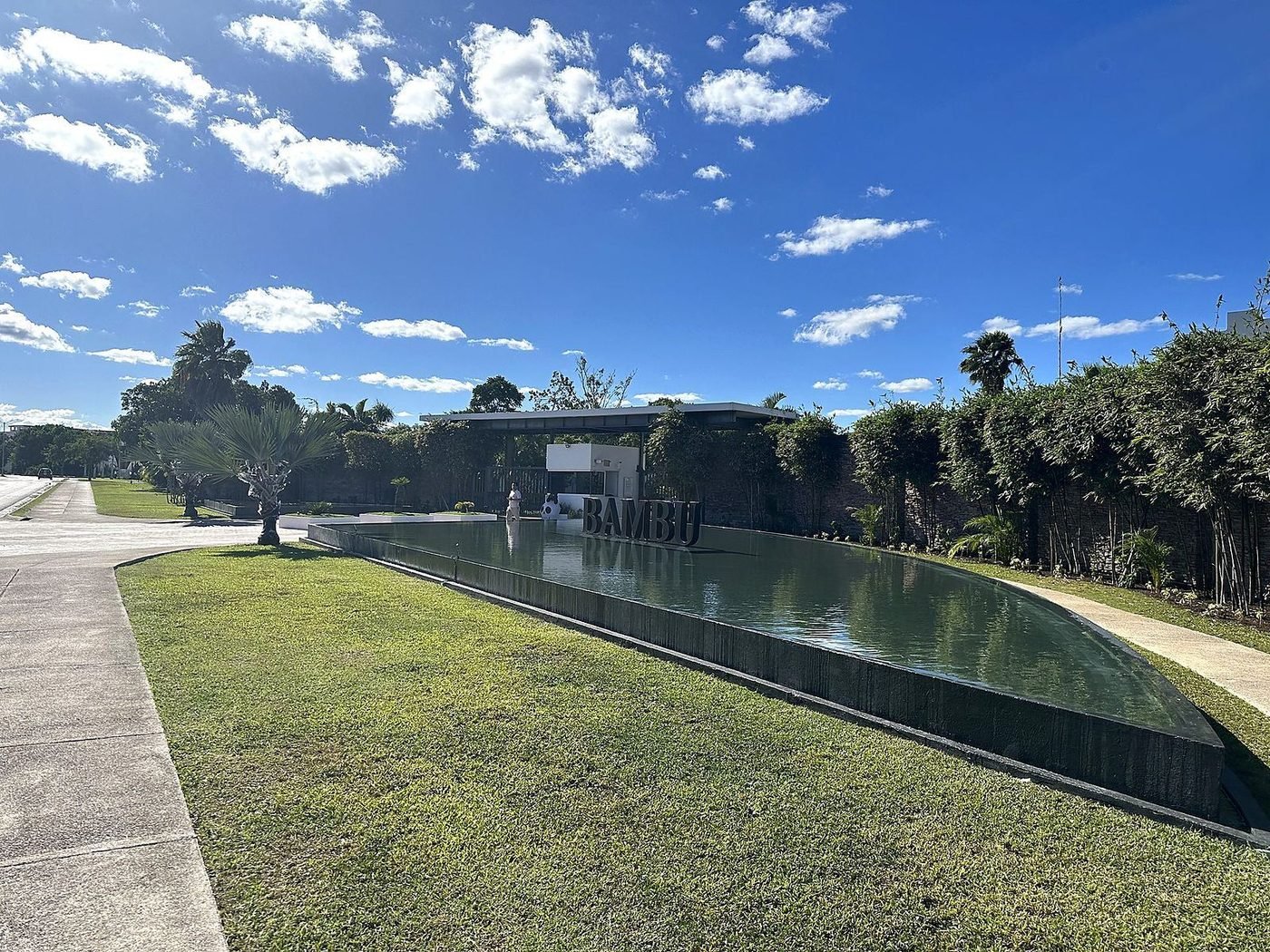 Ingang van Residencial Bambu met waterpartij en naambord