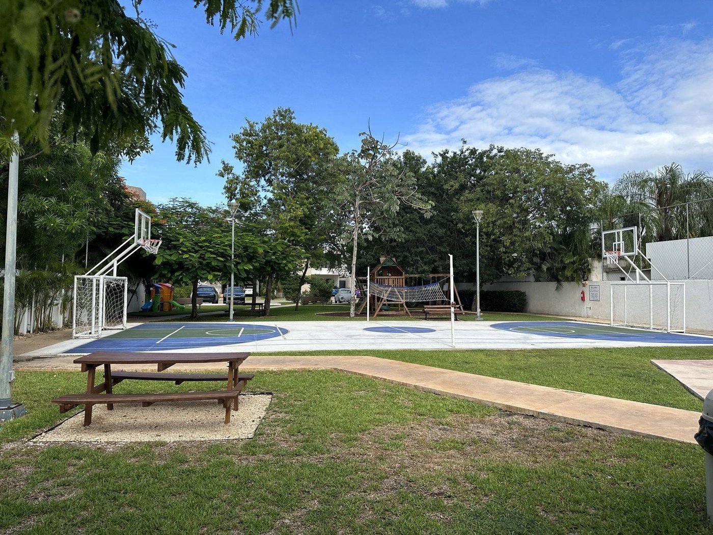 Gemeenschappelijk voetbal- en basketbalveld met picknicktafel en speeltuin