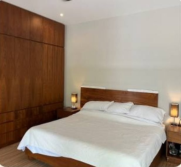 Slaapkamer met wit linnen en houtafwerking